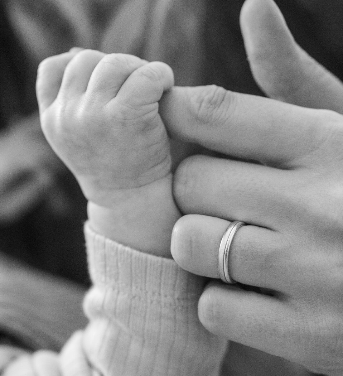 Hand einer Mutter und eines Kindes bei der Familienfotografie